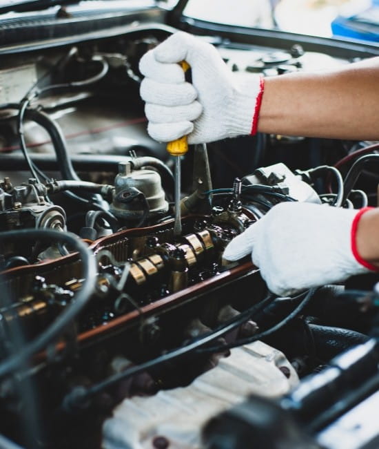 Technician performing engine maintenance at One Stop Lube.