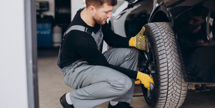 Professional wheel alignment being performed on a black car in Orlando auto repair shop.