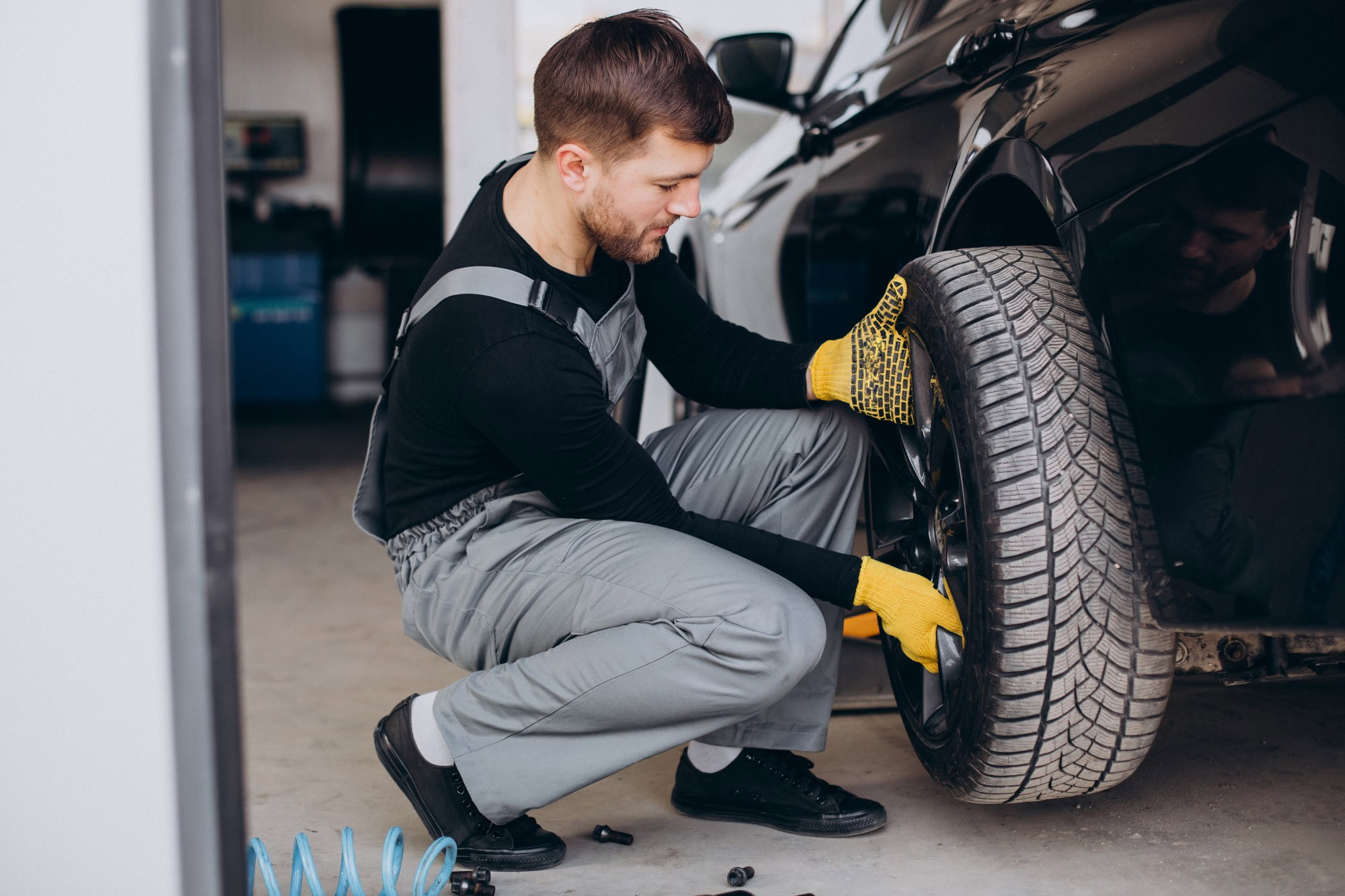 Professional wheel alignment being performed on a black car in Orlando auto repair shop.