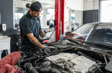 Engine repair technician working on a car engine in Orlando Auto Repair shop.