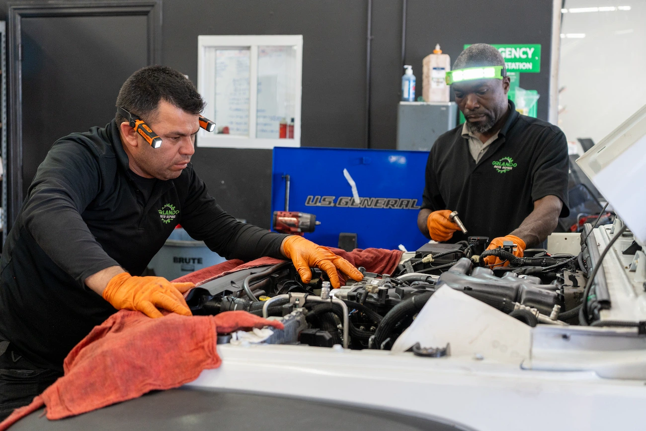 Engine repair technicians working on a vehicle engine at Orlando Auto Repair.