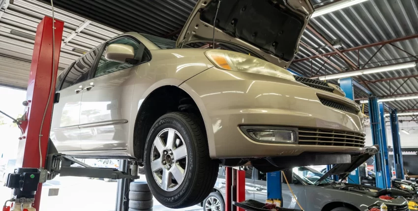 Car on lift at Orlando auto repair shop for maintenance and repairs.
