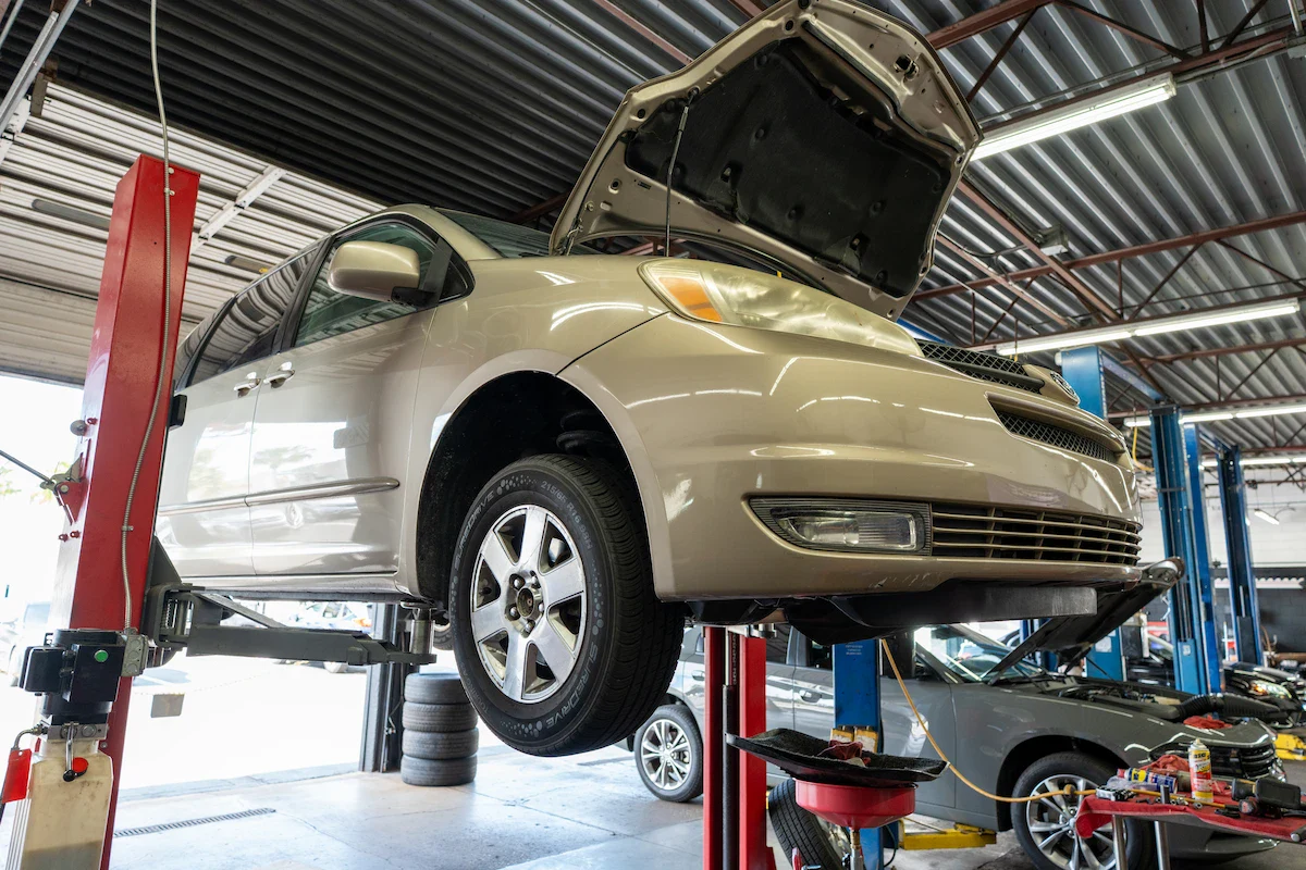 Car on lift at Orlando auto repair shop for maintenance and repairs.