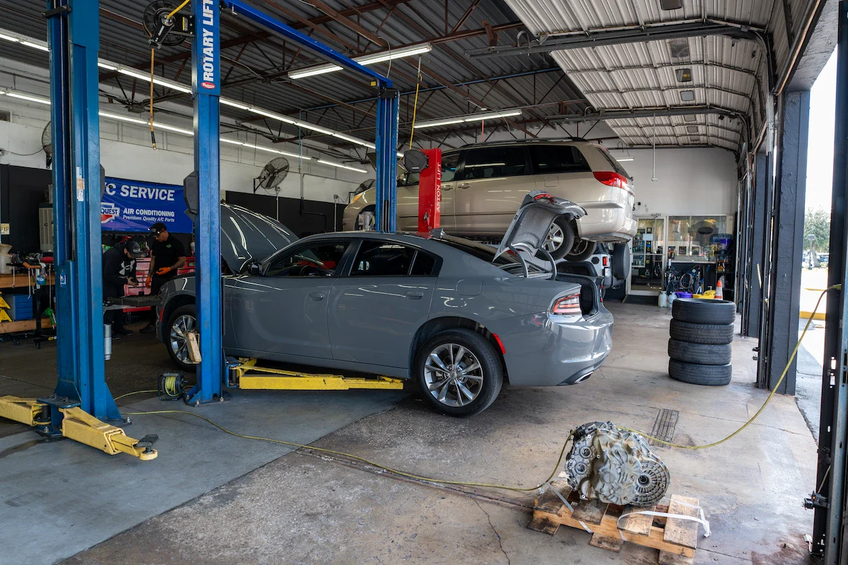 Auto repair shop with cars on lifts and engine work in progress.