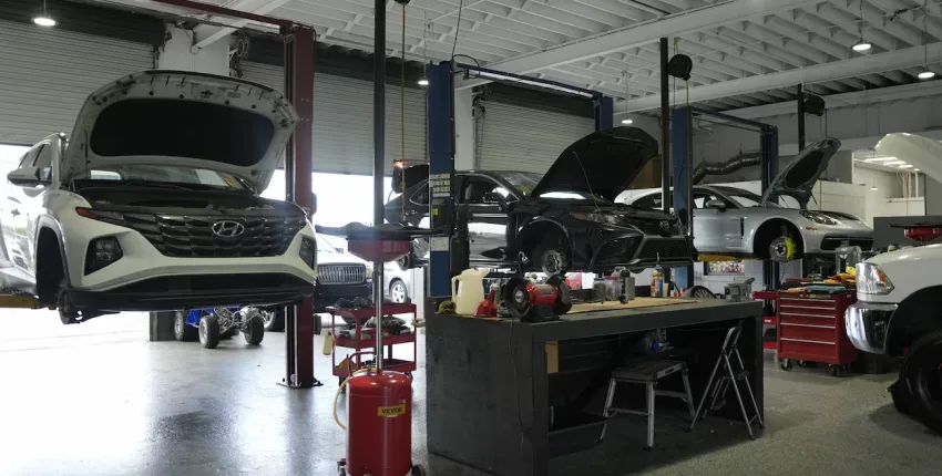 Auto repair shop with Hyundai and other vehicles on lifts and tools.