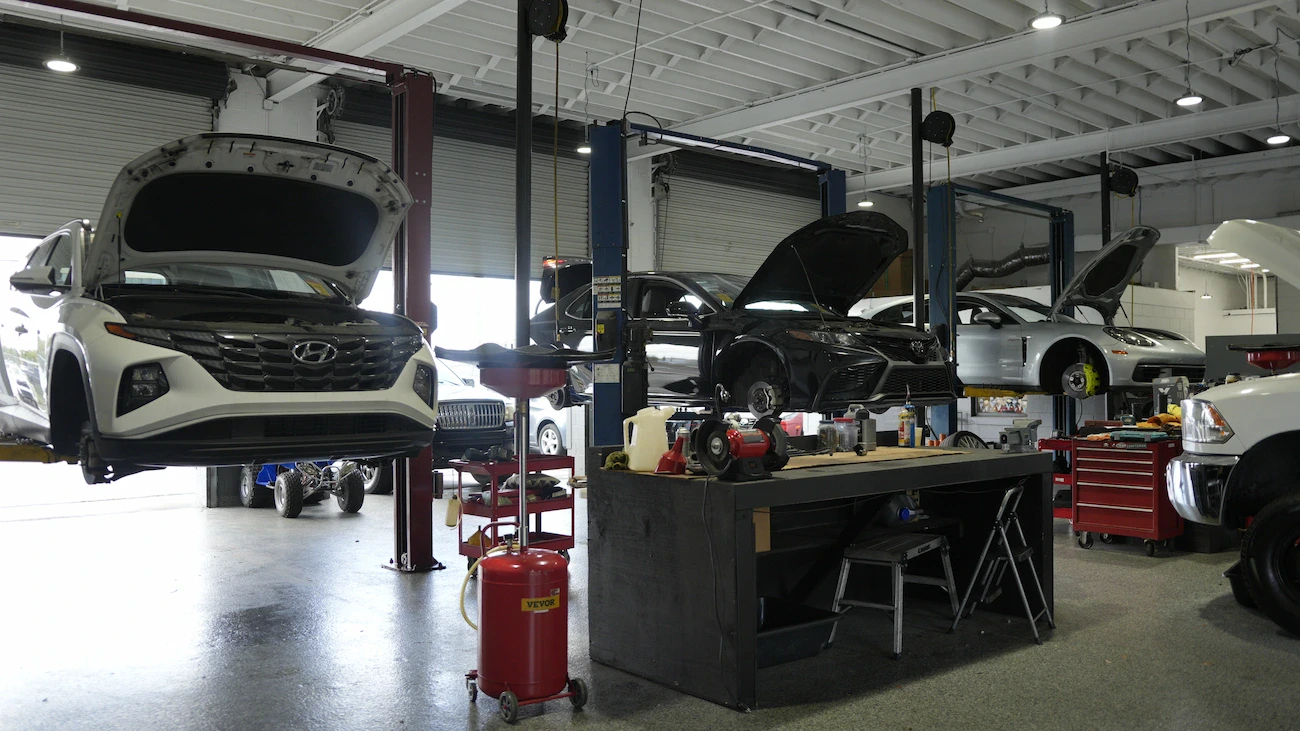 Auto repair shop with Hyundai and other vehicles on lifts and tools.