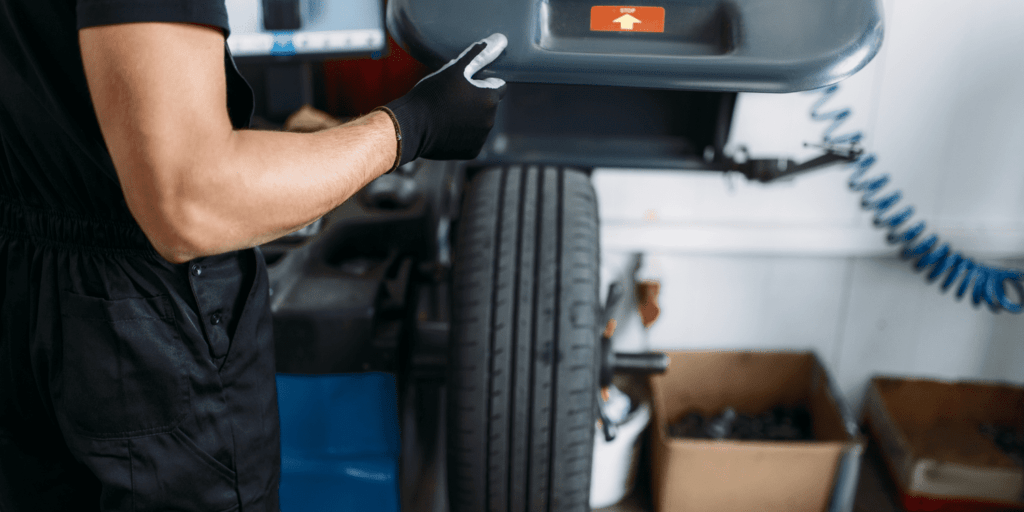 Technician inspecting a diesel truck tire at Panhandle Diesel Performance LLC.