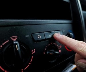 Person adjusting car air conditioning and climate controls.