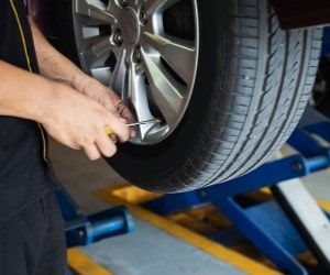 Technician changing a car tire during quick lube service at Parney’s Car Care.