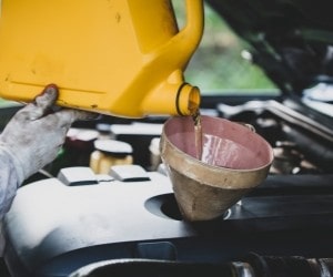 Oil being poured into a car engine during maintenance at Parney’s Car Care.