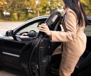 Woman opening car door during vehicle service at Parney’s Car Care.