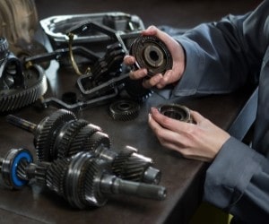 Technician inspecting car transmission parts at Parney’s Car Care.