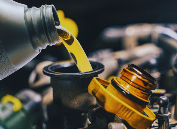 Fresh motor oil being poured into a car engine for maintenance.