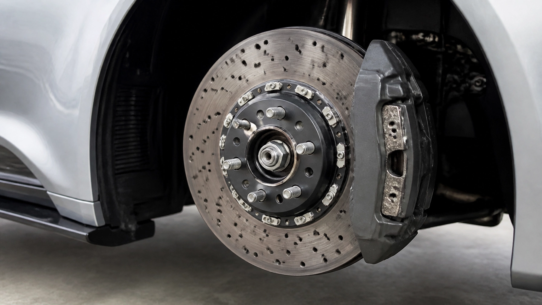 Close-up of a car's brake disc and caliper during maintenance at Parney’s Car Care.