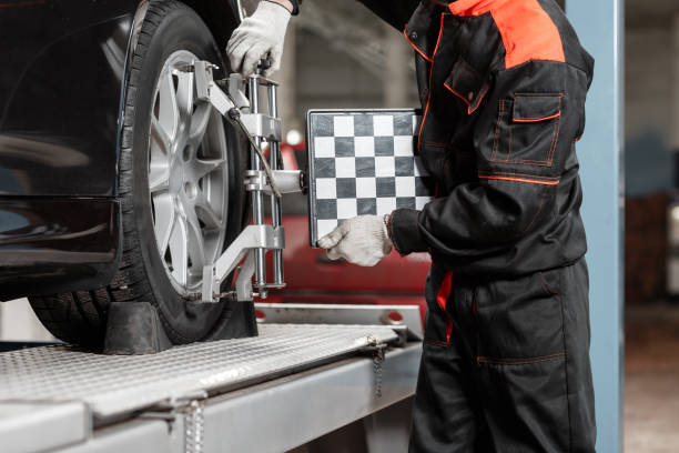 Auto repair technician inspecting a car tire at Pembina Valley Auto.