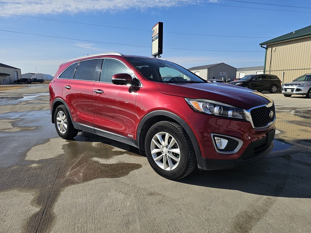 Red Kia Sorento SUV for sale at Pembina Valley Auto dealership.
