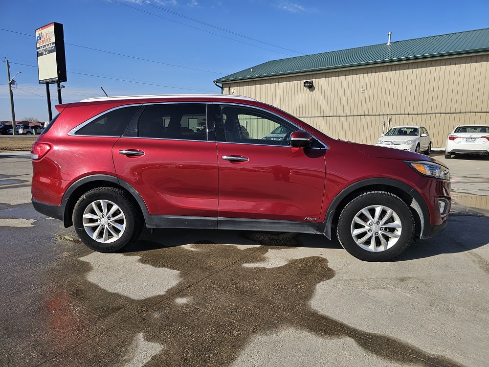 Red SUV parked outdoors with dealership building in background.