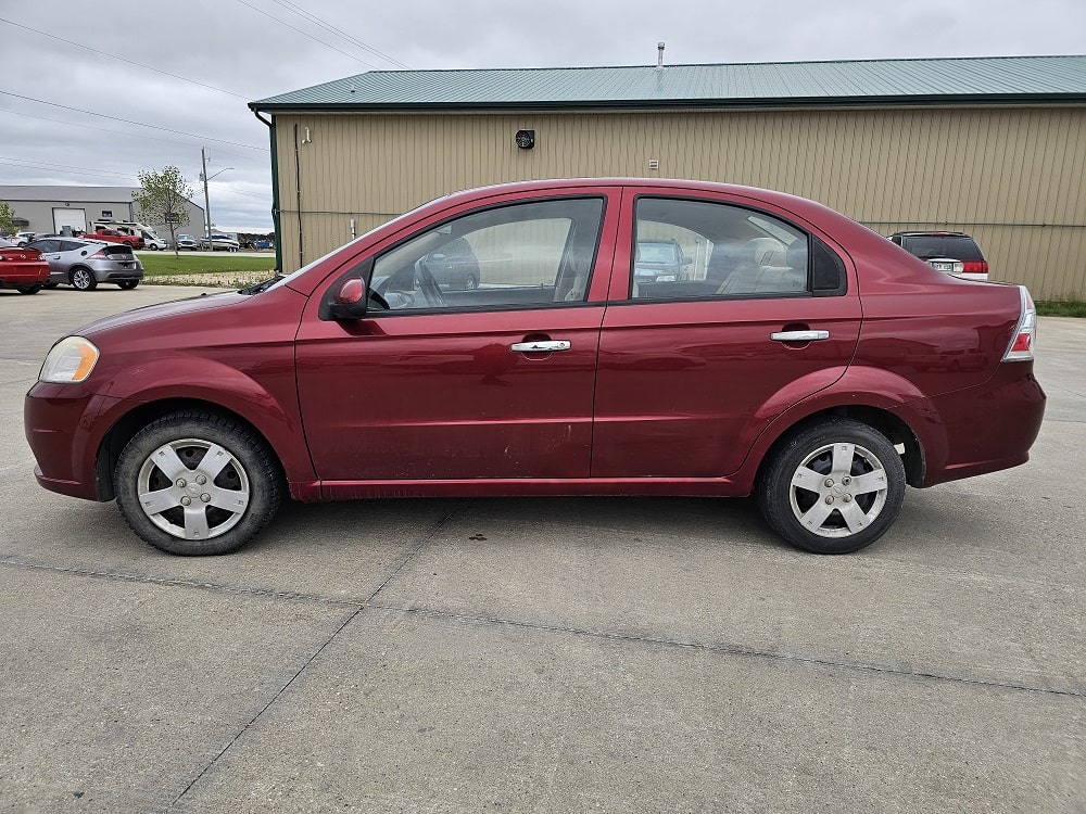 Red sedan for sale in Pembina Valley, part of vehicle sales inventory.