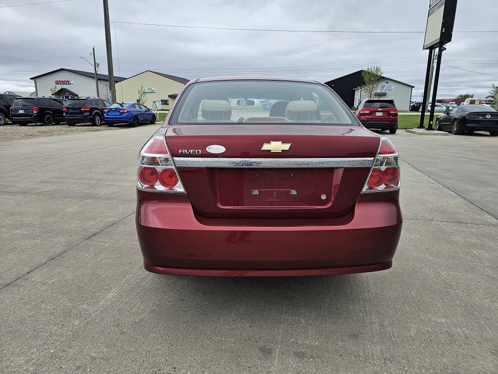 Rear view of a red Chevrolet sedan in the vehicle lot.