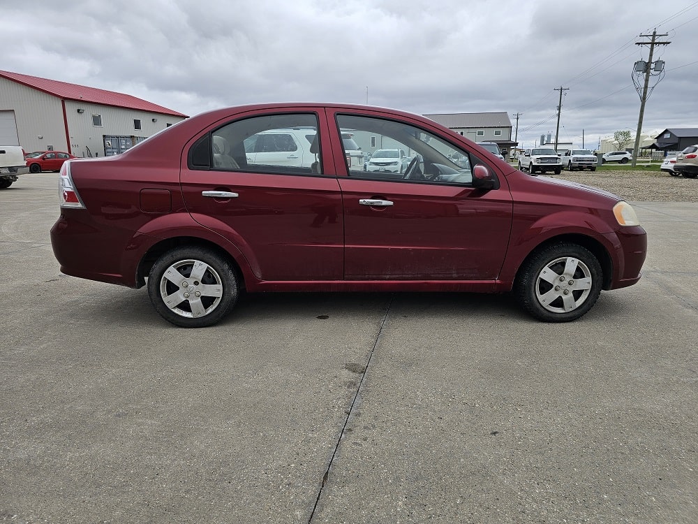 Pre-owned red sedan available for sale at Pembina Valley Auto dealership.