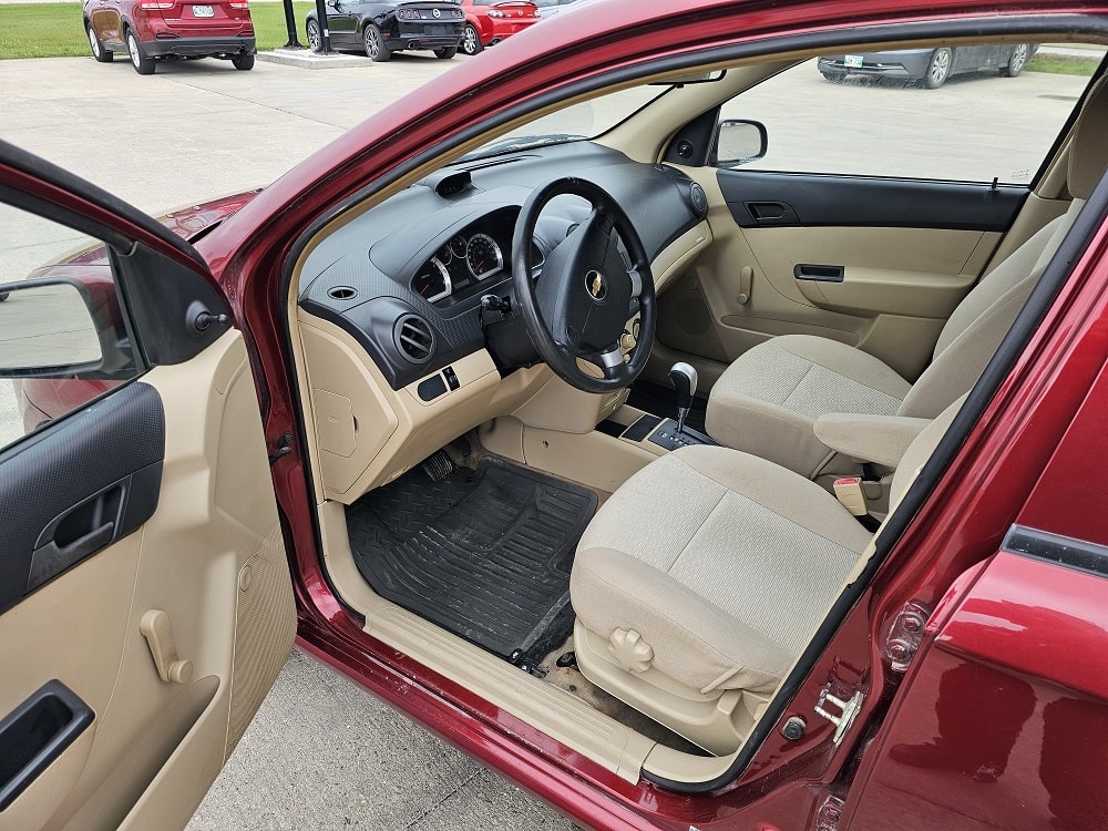 View of the beige interior of a red vehicle at Pembina Valley Auto dealership.