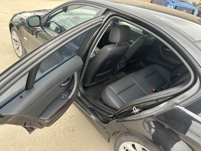 Interior view of a black sedan showing the back seat and door panel.