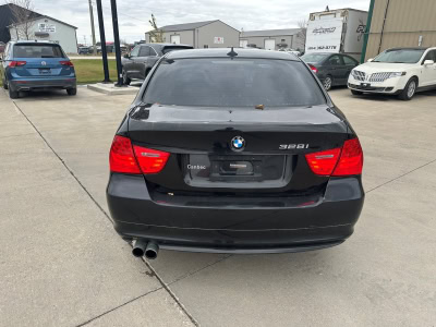 Black BMW 328i sedan parked at Pembina Valley Auto dealership.