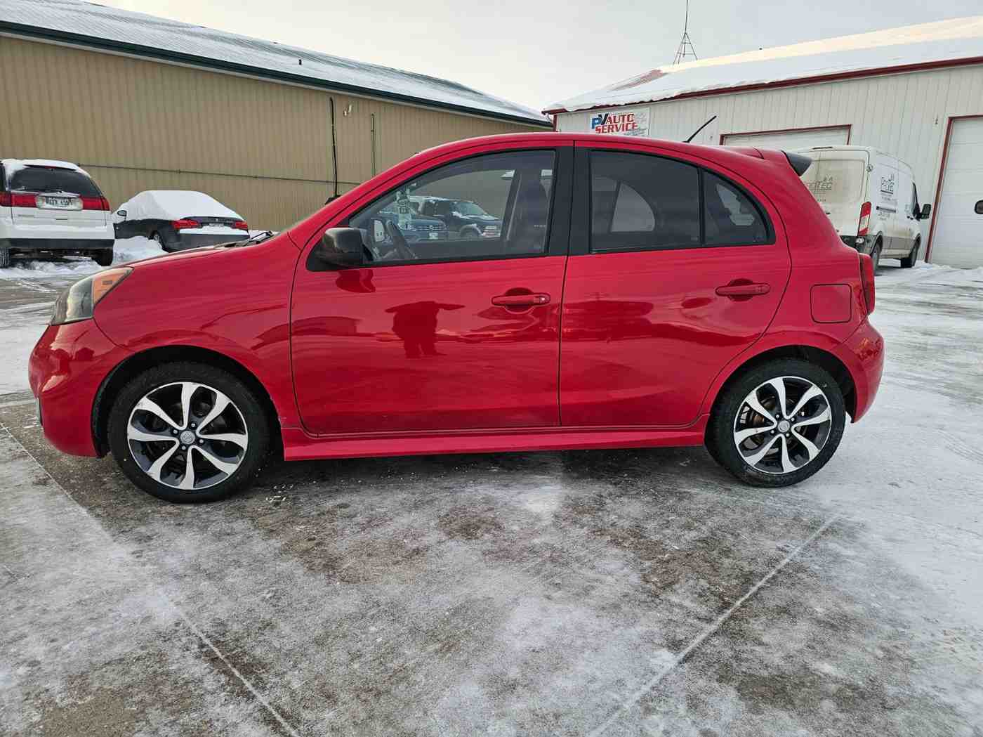 Red compact car parked outdoors in Pembina Valley, Manitoba.