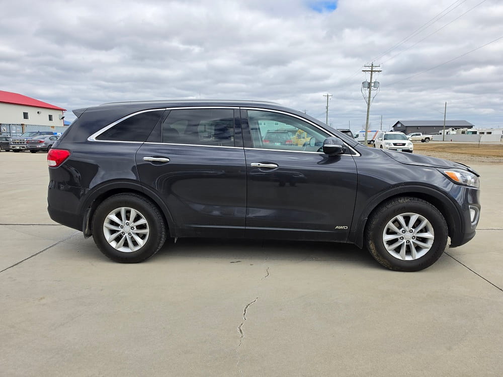 Black SUV parked outdoors at Pembina Valley Auto dealership.