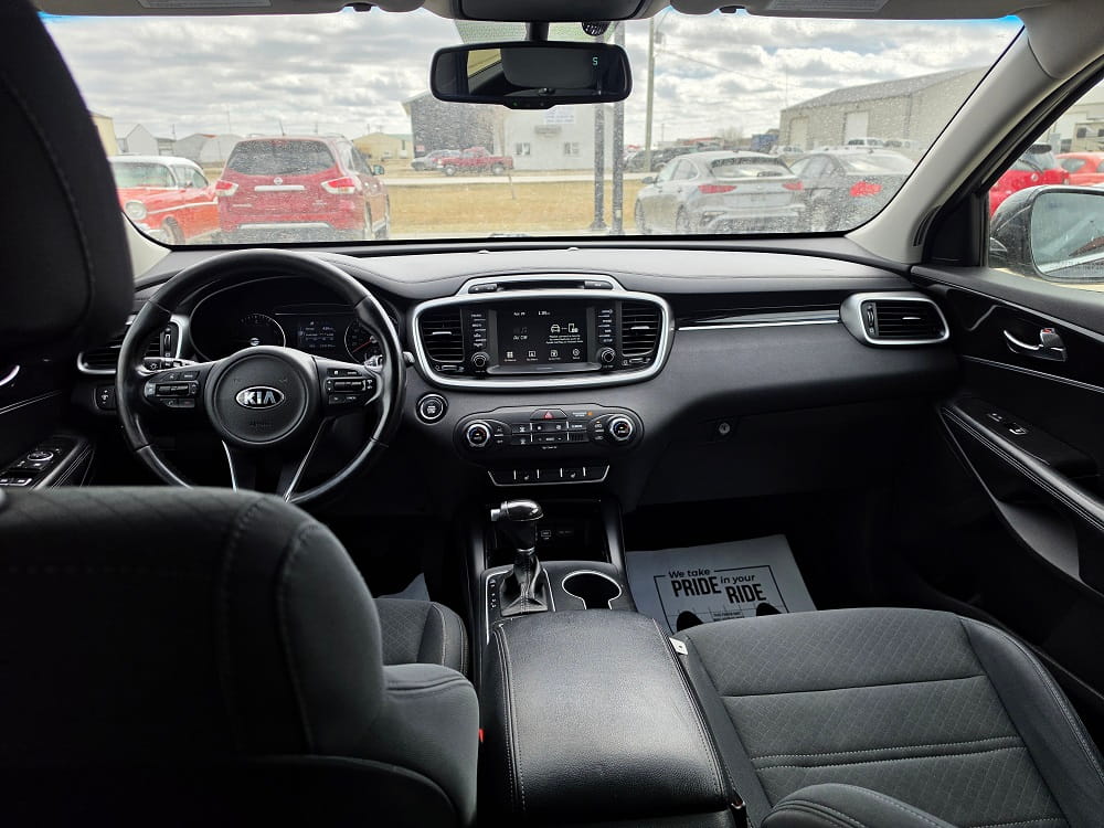 Modern Kia vehicle interior with dashboard and steering wheel at Pembina Valley Auto.