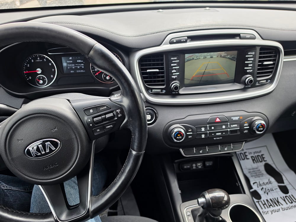 Kia car dashboard with infotainment screen and steering wheel.