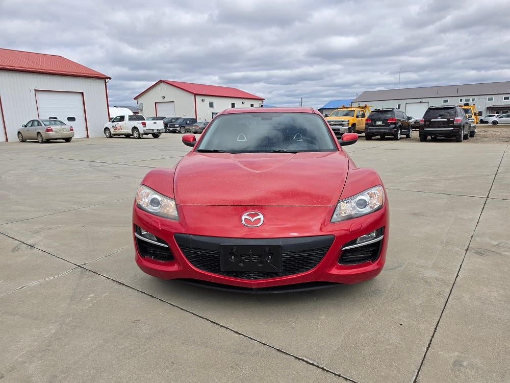 Red Mazda sports car with sleek design parked outdoors at Pembina Valley Auto.