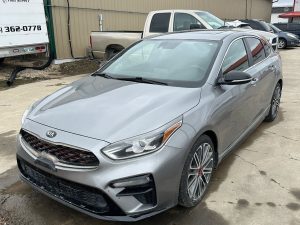 Silver Kia Forte sedan parked outside Pembina Valley auto dealership.