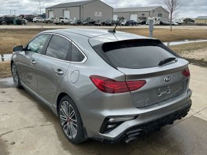 Silver Kia Forte GT sedan parked outdoors on a cloudy day.