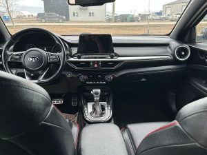 Kia car interior dashboard with touchscreen and controls.