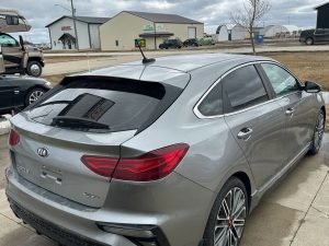 Silver Kia Forte GT sedan parked outside Pembina Valley Auto dealership.