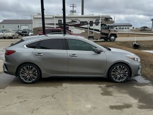 Silver sedan parked outside Pembina Valley Auto dealership.