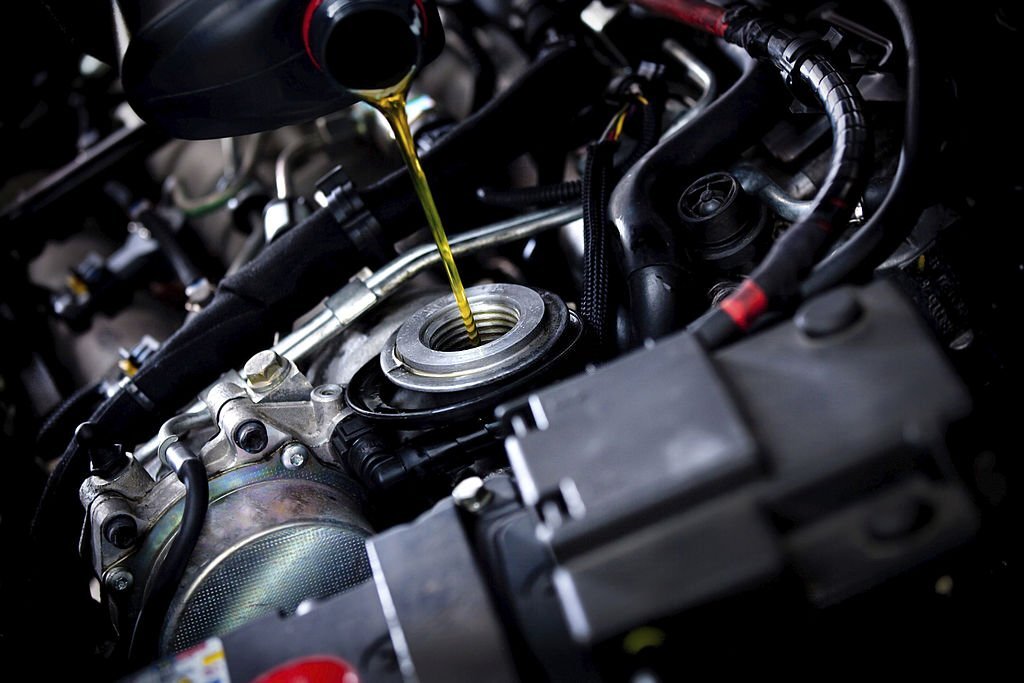Engine oil being poured into a car engine during maintenance at Performance Authority.
