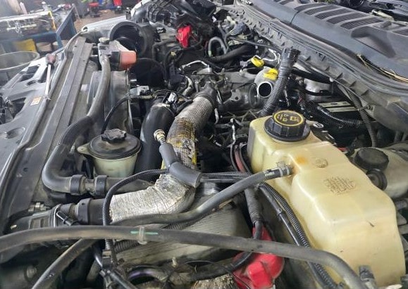 Close-up of a vehicle engine showing various components and hoses.