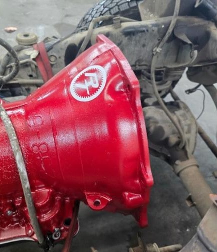 Red transmission housing with Performance Authority logo on vehicle chassis.