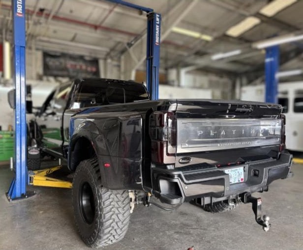 Heavy-duty black truck on lift at Performance Authority in Bend, OR.