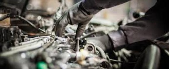 Engine repair technician working on a vehicle engine.