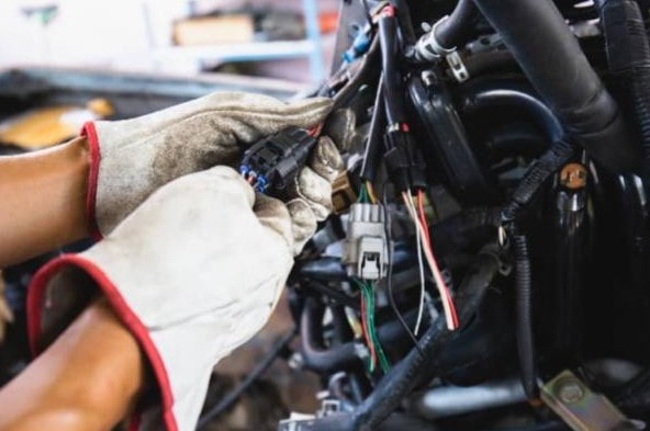 Skilled technician performing engine diagnostics on a vehicle at Performance Authority.