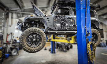Off-road vehicle lifted on a hydraulic lift at Performance Authority.