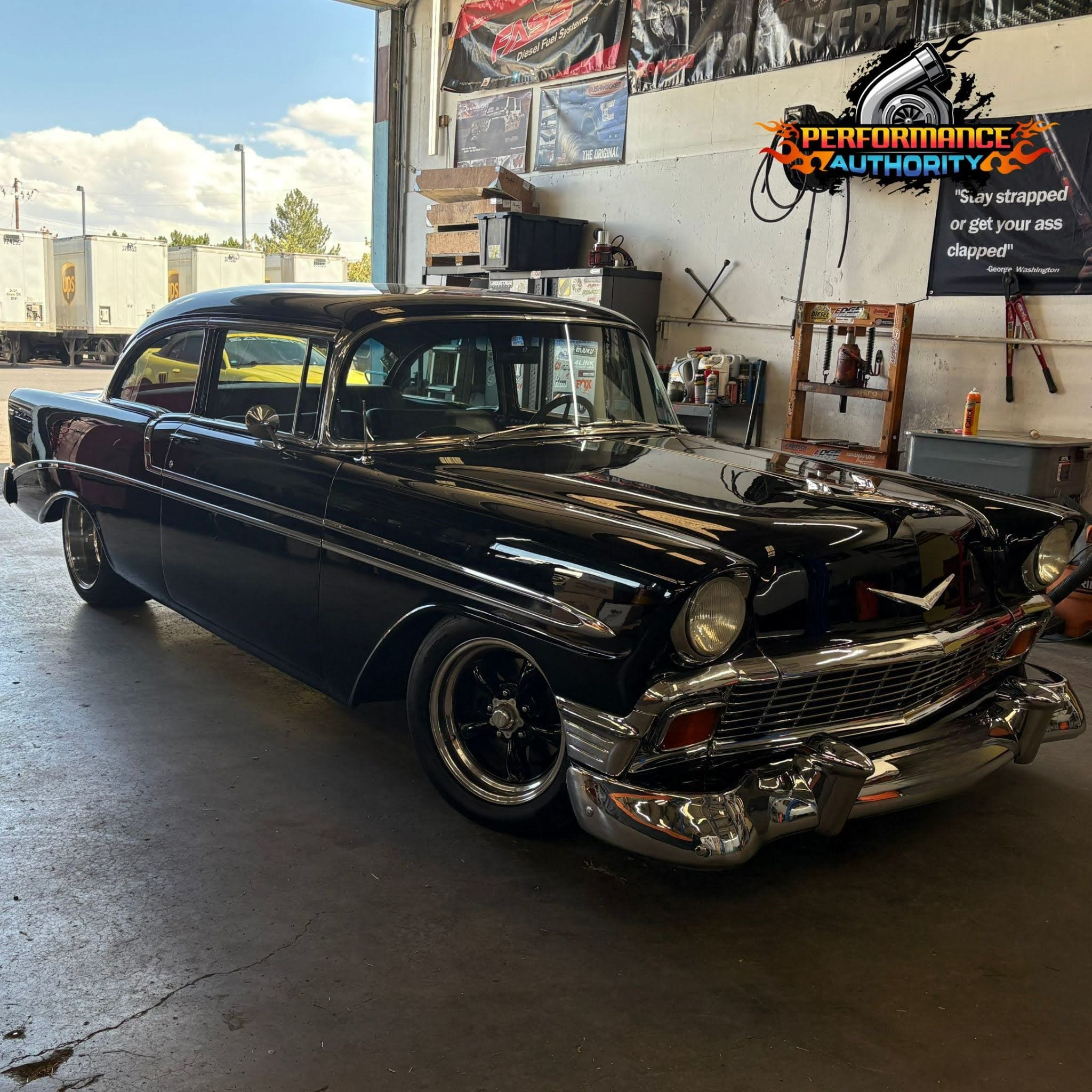 Vintage black classic car inside Performance Authority workshop.