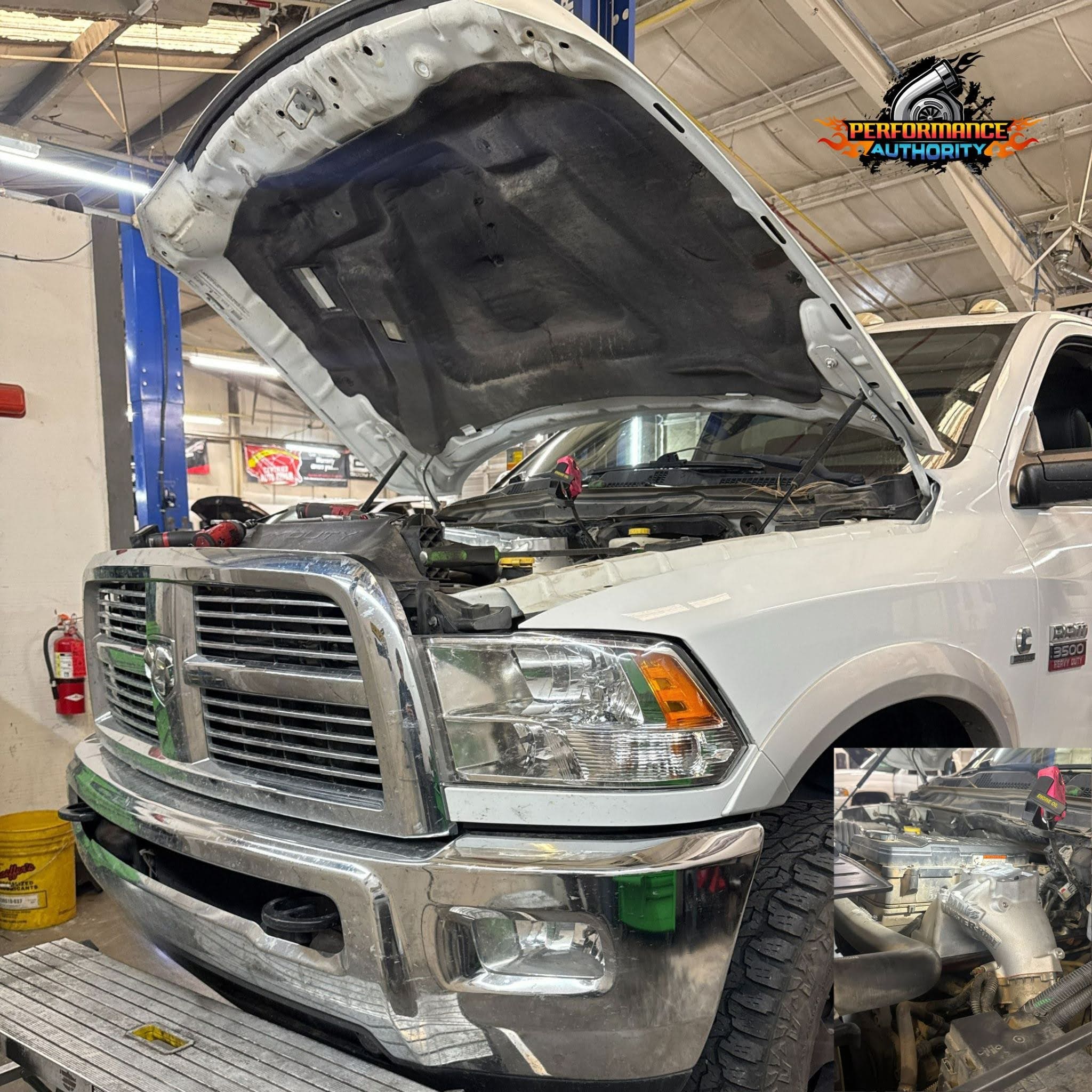 Skilled technicians repairing a white RAM truck engine at Performance Authority.