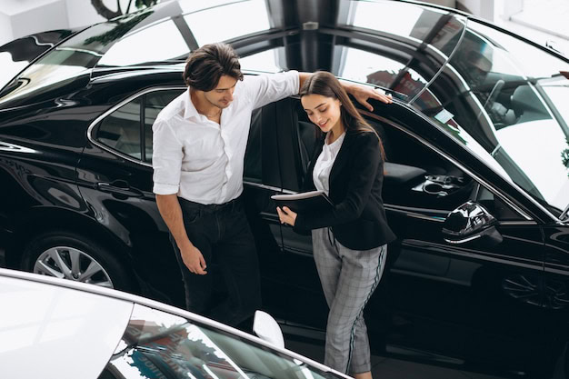 Business professionals discussing car options at Performance Authority dealership.