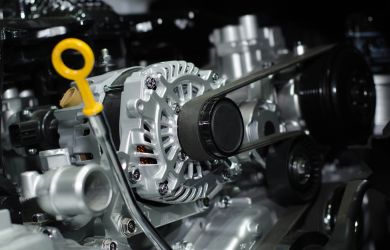 Close-up of car engine parts and belts at Phantom Auto Repair shop.