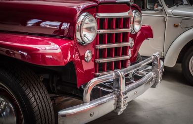 Vintage red truck with chrome bumper and grille at Phantom Auto Repair shop.