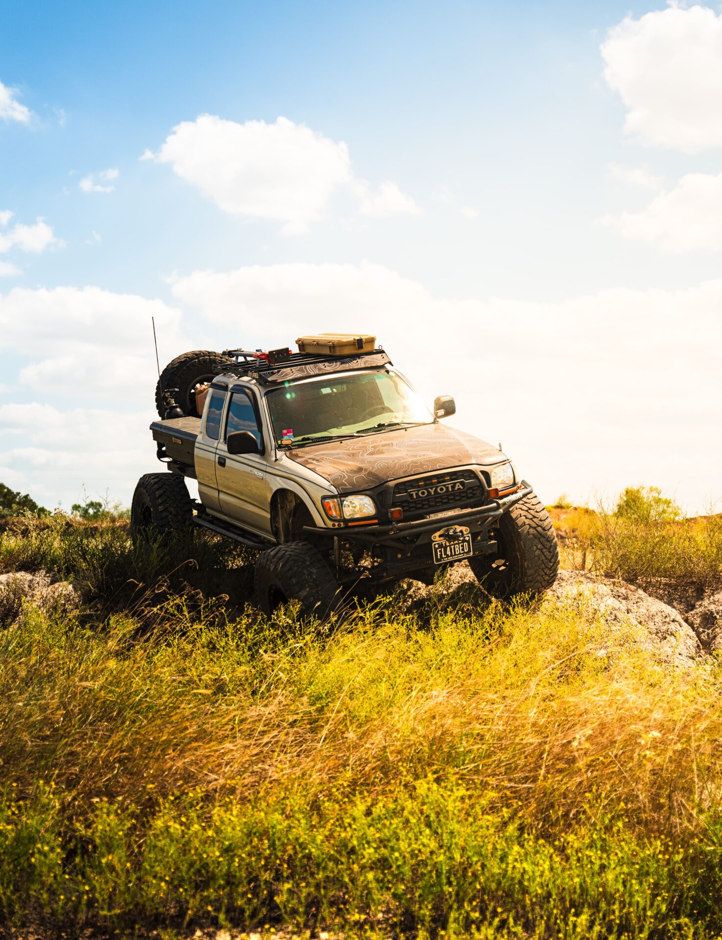Off-road Toyota truck with lifted suspension and large tires for rough terrain.